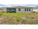 Spacious backyard with green grass and a view of the screened-in lanai and home exterior at 17032 Harvest Moon Way, Bradenton, FL 34211