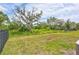 Wide view of a grassy backyard with mature trees and black fencing at 17032 Harvest Moon Way, Bradenton, FL 34211