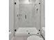 Modern tiled bathroom with a glass-enclosed shower featuring a shower head and convenient shelving at 17032 Harvest Moon Way, Bradenton, FL 34211
