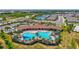 A lively community pool area with a unique shape, ample seating, and lush landscaping for a relaxing atmosphere at 17032 Harvest Moon Way, Bradenton, FL 34211