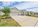 Charming single-story home with a three-car garage and neat landscaping under blue skies at 17032 Harvest Moon Way, Bradenton, FL 34211