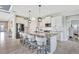 Bright kitchen featuring a large island with seating, white cabinets, and stainless-steel appliances at 17032 Harvest Moon Way, Bradenton, FL 34211