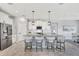 Modern kitchen features a large island with bar seating, stylish pendant lighting and tiled flooring at 17032 Harvest Moon Way, Bradenton, FL 34211