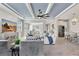 Open-concept living area with a coffered ceiling, tile floors, and a view of the modern kitchen at 17032 Harvest Moon Way, Bradenton, FL 34211