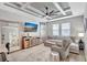 Inviting living room with coffered ceiling, fan, modern furniture, and large windows, offering natural light at 17032 Harvest Moon Way, Bradenton, FL 34211
