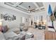 Inviting living room with coffered ceiling, fan, comfortable seating, and a functional work space at 17032 Harvest Moon Way, Bradenton, FL 34211
