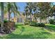 The backyard features a sliding door, manicured landscaping, and mature palm trees at 1831 Burgos Dr, Sarasota, FL 34238