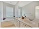 Bathroom with dual sinks, large mirror, and separate tub at 1831 Burgos Dr, Sarasota, FL 34238