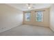 Well-lit bedroom with two windows, ceiling fan, and neutral color palette at 1831 Burgos Dr, Sarasota, FL 34238
