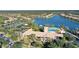 Beautiful aerial view of clubhouse, swimming pool, tennis courts, and lake in a gated community at 1831 Burgos Dr, Sarasota, FL 34238