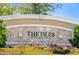 Close-up of The Isles on Palmer Ranch sign enhanced by colorful flowers and greenery at 1831 Burgos Dr, Sarasota, FL 34238