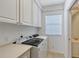 Well-equipped laundry room with modern washer, dryer, cabinets, and counter for folding at 1831 Burgos Dr, Sarasota, FL 34238