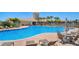 Community pool with lounge chairs and tables with lush landscaping at 1831 Burgos Dr, Sarasota, FL 34238