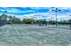 View of community tennis courts with covered seating and shade trees at 1831 Burgos Dr, Sarasota, FL 34238