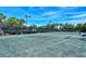 View of a well-maintained tennis court with lush landscaping at 1831 Burgos Dr, Sarasota, FL 34238