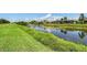 Scenic water view of the property with lush green banks and landscaping of the surrounding homes in the background at 1831 Burgos Dr, Sarasota, FL 34238