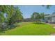 Large, grassy backyard featuring a brick patio, mature trees, and a combination of wood and white fencing at 1857 Jasmine Dr, Sarasota, FL 34239