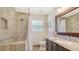 The bathroom has stone tile in the shower with a rainfall showerhead, matching stone tile on the floors and vanity at 1857 Jasmine Dr, Sarasota, FL 34239
