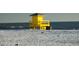 A picturesque yellow lifeguard tower on the pristine sandy beach at 1857 Jasmine Dr, Sarasota, FL 34239