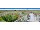 Picturesque beach access with boardwalk, vegetation, and clear blue skies in Siesta Key at 1857 Jasmine Dr, Sarasota, FL 34239