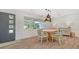 Bright dining room with wood-look floors, stylish lighting, and views to the front yard at 1857 Jasmine Dr, Sarasota, FL 34239