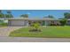 Charming single-story home with a well-manicured lawn, brick driveway, and inviting curb appeal at 1857 Jasmine Dr, Sarasota, FL 34239