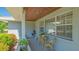 Charming covered porch with wicker seating and lush plantings creating a cozy outdoor space at 1857 Jasmine Dr, Sarasota, FL 34239