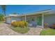 Inviting front porch with seating area, vibrant flowers, and a distinctive green front door at 1857 Jasmine Dr, Sarasota, FL 34239