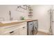 Modern laundry room with a wood countertop, utility sink, and stainless steel washer/dryer at 1857 Jasmine Dr, Sarasota, FL 34239