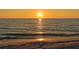 Golden sunset reflecting on the calm ocean waters, with a sandy beach in the foreground at 1857 Jasmine Dr, Sarasota, FL 34239