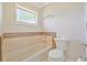 Bathroom featuring tile accents around the tub and a modern toilet at 2136 Bendway Dr, Port Charlotte, FL 33948