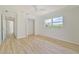 Spacious bedroom with wood-look flooring, ceiling fan, and hall access at 2136 Bendway Dr, Port Charlotte, FL 33948