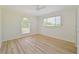 Bright bedroom featuring a ceiling fan, wood-look flooring, and natural light from large windows at 2136 Bendway Dr, Port Charlotte, FL 33948