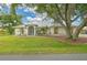 Charming single-story home with a lush green lawn, mature trees, and well-maintained landscaping at 2136 Bendway Dr, Port Charlotte, FL 33948