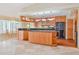 Another view of the kitchen featuring wood cabinetry, black countertops, and views into dining area at 2136 Bendway Dr, Port Charlotte, FL 33948