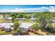 Aerial view shows house with white roof, small shed, dry backyard lawn, and neighborhood street at 21966 Belinda Ave, Port Charlotte, FL 33952