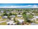 Aerial view shows residential neighborhood with manicured lawns and mature trees in the suburban landscape at 21966 Belinda Ave, Port Charlotte, FL 33952