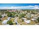 Aerial view captures a residential neighborhood in a sunny, suburban setting with mature trees and local businesses at 21966 Belinda Ave, Port Charlotte, FL 33952