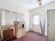 Bedroom features white paint, window with curtains, filing cabinet, and indoor-outdoor access at 21966 Belinda Ave, Port Charlotte, FL 33952