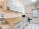 Kitchen with laminate countertops, white cabinets, and tile flooring at 21966 Belinda Ave, Port Charlotte, FL 33952