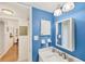 Modern bathroom features a blue accent wall, vanity sink, and well-lit mirror and lighting at 2280 Stickney Point Rd # 420, Sarasota, FL 34231
