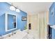 Bright bathroom features a modern vanity, blue walls, and a bathtub-shower with modern fixtures at 2280 Stickney Point Rd # 420, Sarasota, FL 34231