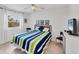 This bedroom features natural light, a ceiling fan, tile flooring, and a coastal-themed bedspread at 2280 Stickney Point Rd # 420, Sarasota, FL 34231