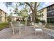 Outdoor seating area with tables and chairs, set amidst mature trees for a peaceful ambiance at 2280 Stickney Point Rd # 420, Sarasota, FL 34231