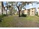 Beautifully landscaped building exterior with a well-maintained lawn and mature trees at 2280 Stickney Point Rd # 420, Sarasota, FL 34231