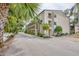 Multi-level condo complex with balconies and mature landscaping; exterior view showcases building architecture and surrounding greenery at 2280 Stickney Point Rd # 420, Sarasota, FL 34231