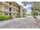 Multi-level condo with balconies, and lush landscaping; exterior view showcasing building architecture and tropical greenery at 2280 Stickney Point Rd # 420, Sarasota, FL 34231