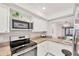 Modern kitchen with stainless steel appliances, granite countertops, and white cabinetry at 2280 Stickney Point Rd # 420, Sarasota, FL 34231
