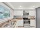 Modern kitchen featuring updated appliances, granite countertops, white cabinetry, and bright lighting at 2280 Stickney Point Rd # 420, Sarasota, FL 34231