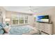 Bright bedroom featuring plantation shutters, beach-themed decor, and a large flat-screen TV at 2306 64Th W St # 17, Bradenton, FL 34209